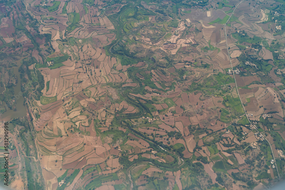 Aerial top view of paddy rice terraces, green agricultural fields in countryside, mountain hills valley, Thailand. Nature landscape. Crops harvest. View from airplane