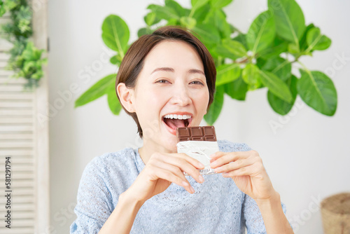 家でチョコレートを食べる女性