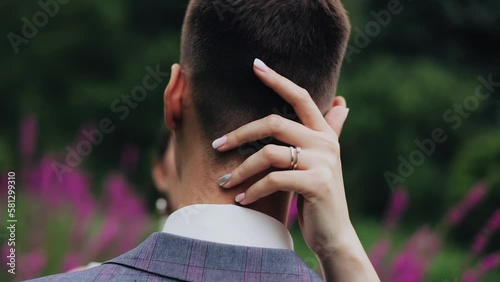 The girl gently strokes her boyfriend on the back of the head. Lovers are facing each other