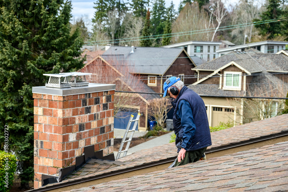 Senior man with a gas powered leaf blower cleaning storm debris off a residential rooftop
Senior man with a gas powered leaf blower cleaning storm debris off a residential rooftop