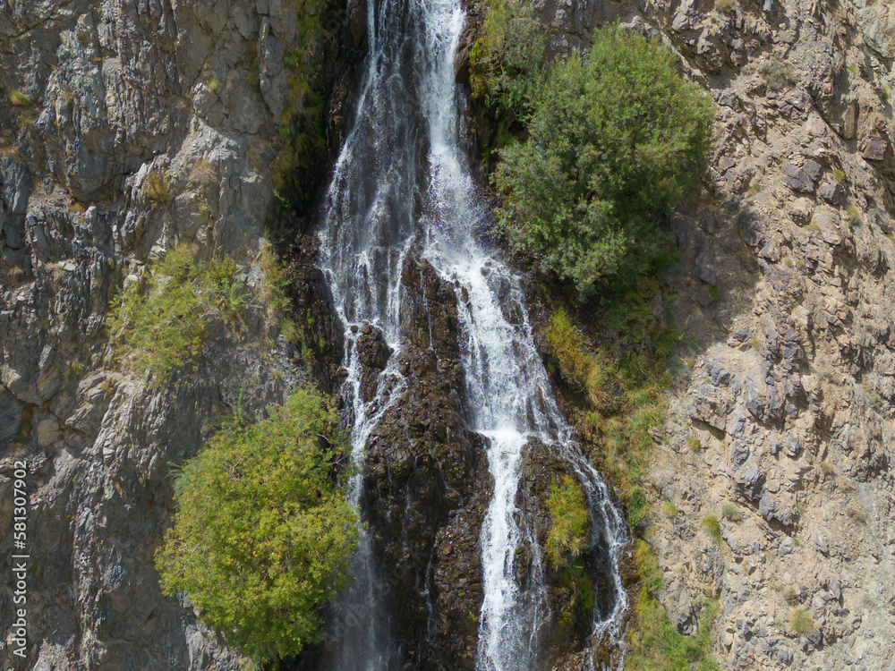 Obraz premium Aerial top view of Mantoka Waterfall in Karakoram high mountain hills. Nature landscape background, Skardu-Gilgit, Pakistan. Travel on holiday vacation.
