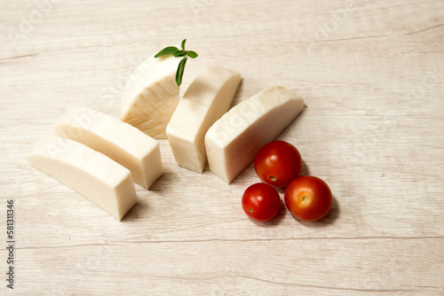 Majorero cheese on the kitchen table with cherry tomatoes. Made with goat's milk, Majorera, Fuerteventura Island. Spain photo