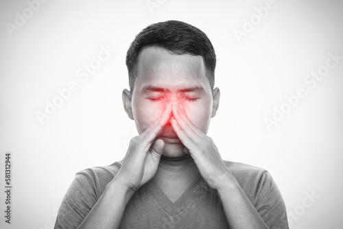 Man suffering from sinus pressure. Man touching his nose. Isolated on gray background. Healthcare and health problem concept photo