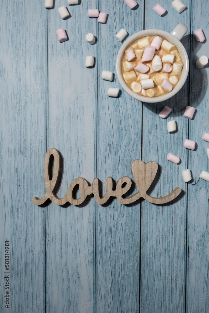 Wooden word love with heart romance with white coffee cup of hot chocolate and small marshmallows. Minimal concept of greeting card for Valentine's Day, Mother's Day, Women's Day Festive holiday card Wooden word love with heart romance with white coffee cup of hot chocolate and small marshmallows. Minimal concept of greeting card for Valentine's Day, Mother's Day, Women's Day Festive holiday card