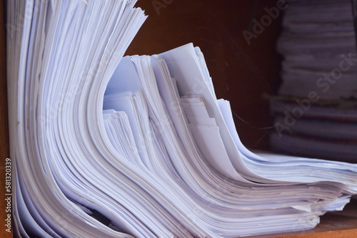 pile of unused papers on top of the cupboard