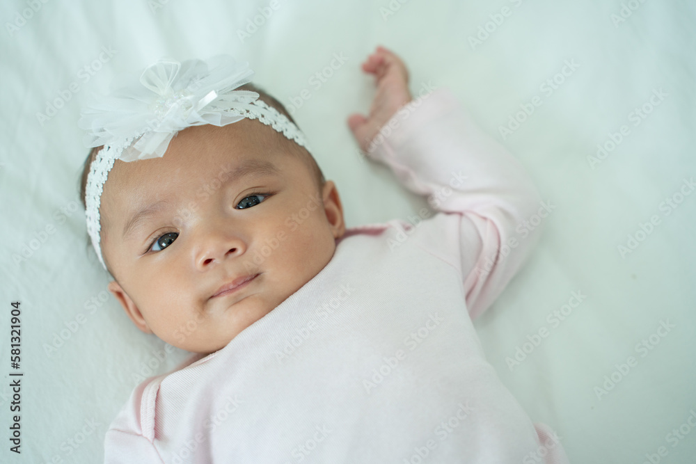 Smiling Cute baby girl lying on a bed sleeping on white sheets Smiling Cute baby girl lying on a bed sleeping on white sheets