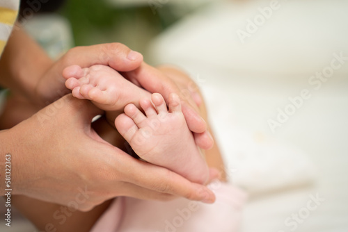 Asian Baby feet in mother's hands that mean symblo of love. Mom and her Baby Child. Happy Family concept. Beautiful conceptual image of Mother and newborn baby family