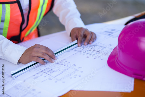 A pair of hands working on an architectural plan with a scaler
