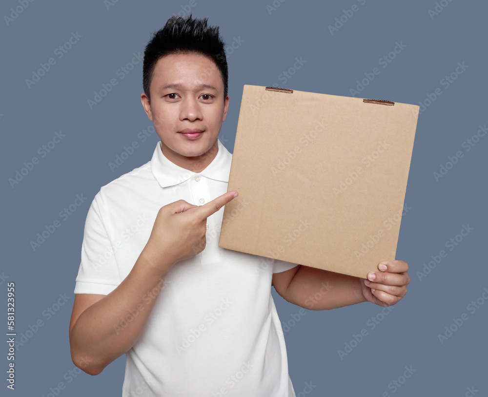 Man holding and pointing at brown cardboard box isolated on plain background. Man holding and pointing at brown cardboard box isolated on plain background.