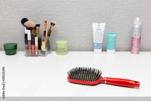 old used hairbrush on the table with cosmetics