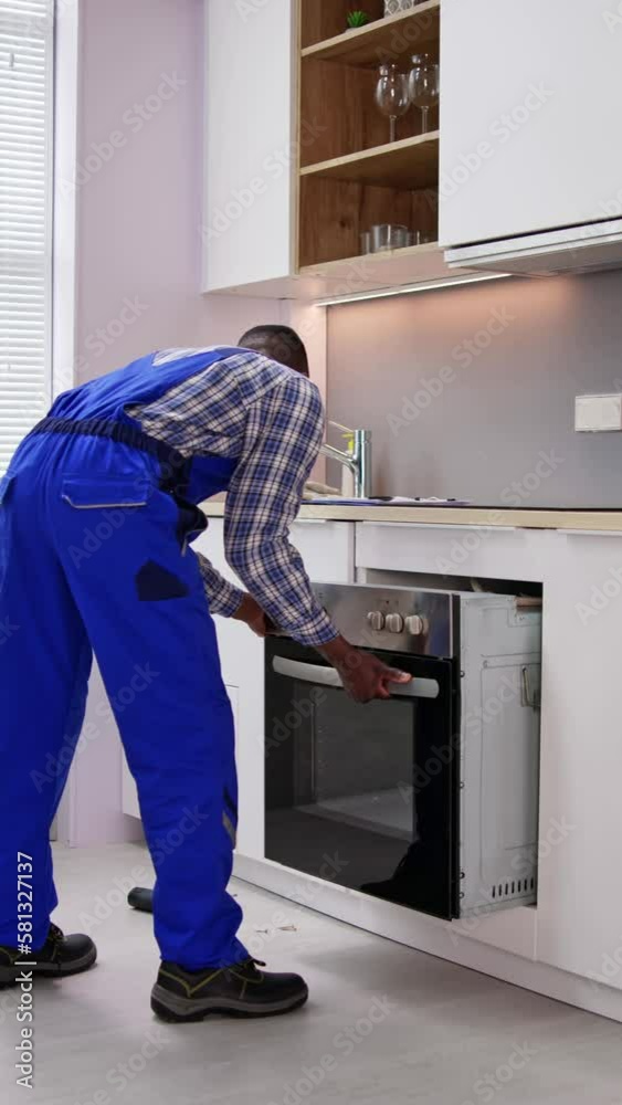 Male Worker Repairing Oven Appliance Male Worker Repairing Oven Appliance