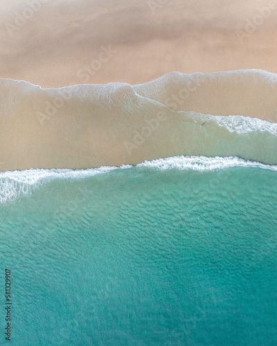 Aerial view of a beach with gentle waves and white sand in a tropical wonderland © FRPhotos
