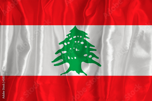The lebanon flag on a silk background is a great national symbol. Texture of fabrics The official state symbol of the country
