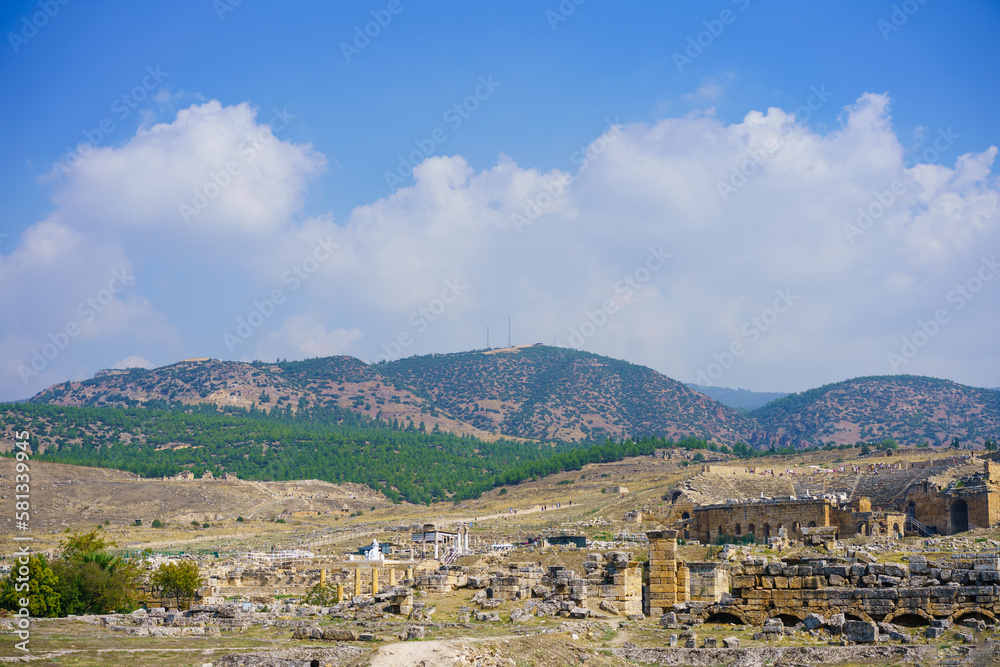 Roman amphitheater in ruins Hierapolis, in Pamukkale, Turkey. UNESCO World Heritage in Turkey. Ruined ancient city in Europe. Popular tourist destination in Turkey against blue sky