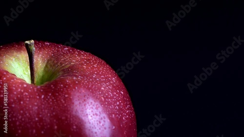 The Enigmatic Apple. A Glistening Fruit with Water Droplets on Dark Background.