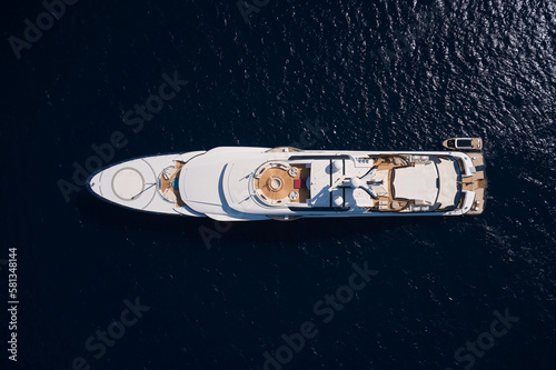 Large luxury white yacht with a helipad anchored in the open sea top view. Mega yacht on a dark background top view.
