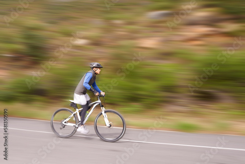 Speeding along on his bike. A young man riding a mountain bike downhill.