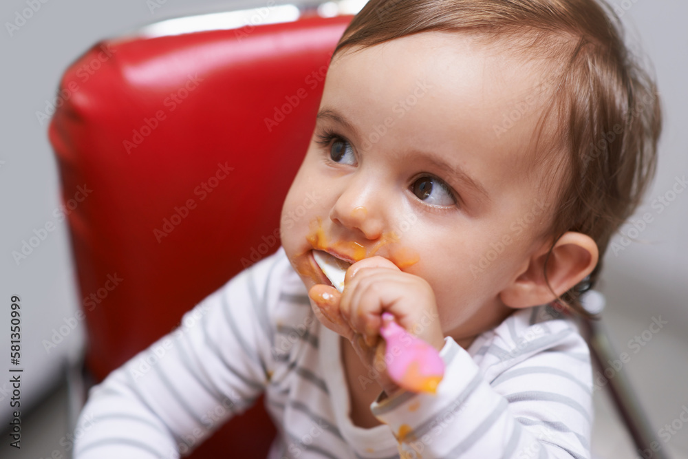 Shes such a cutie. a cute little baby sitting in a high chair eating. Shes such a cutie. a cute little baby sitting in a high chair eating.