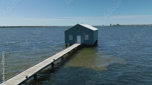Aerial rising orbit shot of blue boat house in Perth, Australia