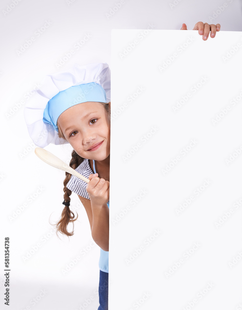 Shes going to chef school - Copyspace. Portrait of a young girl dressed in cooking attire peering from behind copyspace. Shes going to chef school - Copyspace. Portrait of a young girl dressed in cooking attire peering from behind copyspace.