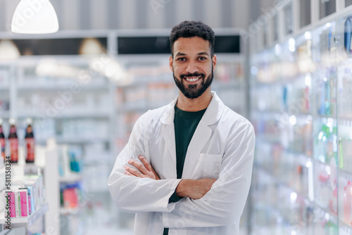 Portrait of young multiracial pharmacist looking at camera, standing in a pharmacy shop. photo