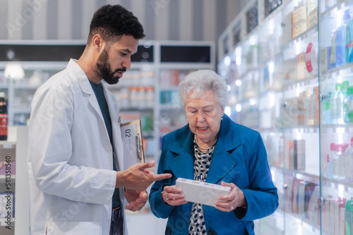 Young pharmacist helping senior woman to choos medication.