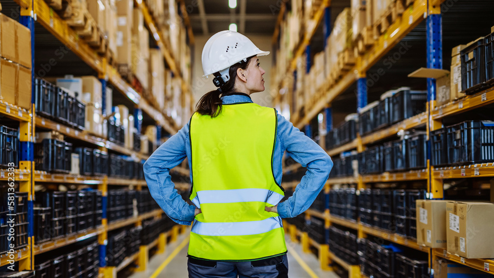 Rear view of warehouse female worker checking up stuff in a warehouse. Rear view of warehouse female worker checking up stuff in a warehouse.