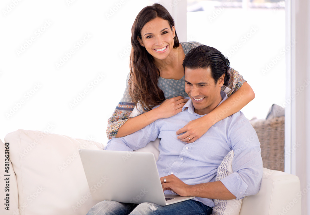 Affectionate wife of a hardworking man. A married couple sitting together on the sofa with a laptop. Affectionate wife of a hardworking man. A married couple sitting together on the sofa with a laptop.