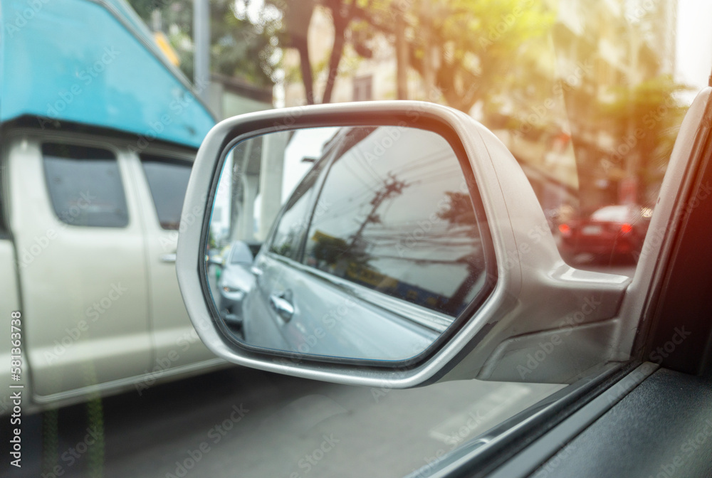 Reflection of a traffic jam in a sideview mirror, look in the rear view mirror of a car.