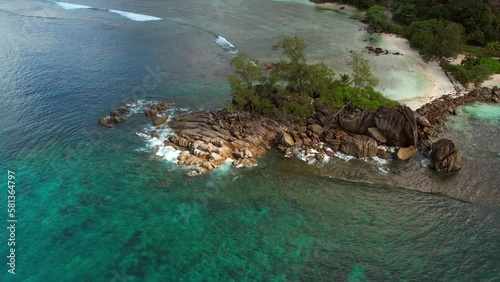 Drone moving towards rock boulders near the beach of Port glaud Mahe, Seychelles Slow motion photo