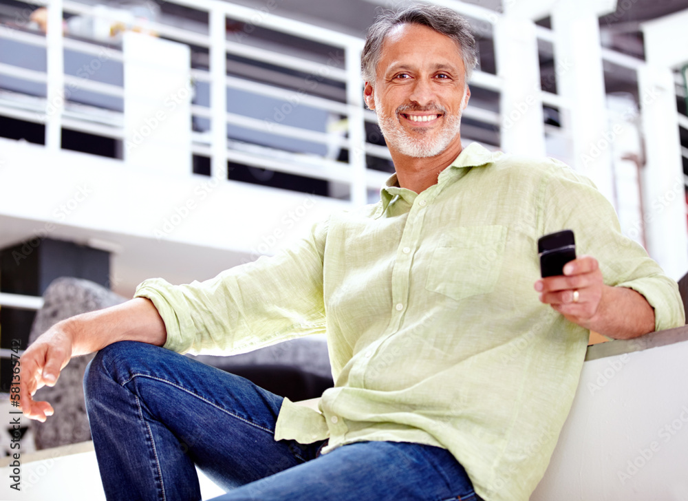 Sending work orders via text message. A mature businessman using his cellphone while sitting in the office. Sending work orders via text message. A mature businessman using his cellphone while sitting in the office.