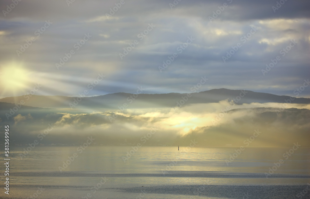 A photo of Sunset, ocean and mountains