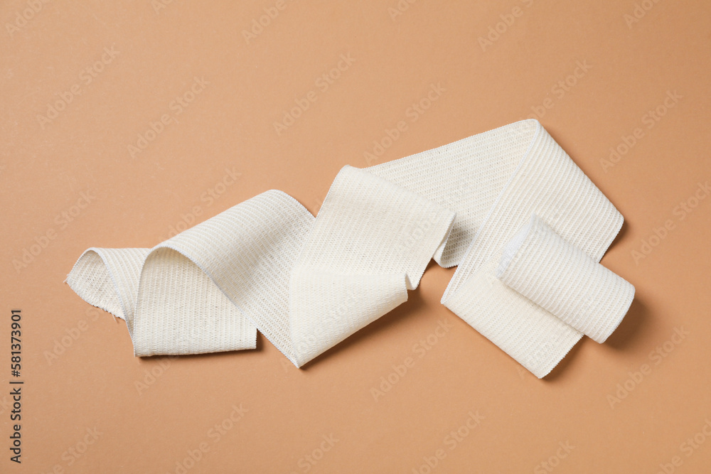 Help during an injury, elastic bandage on beige background Help during an injury, elastic bandage on beige background