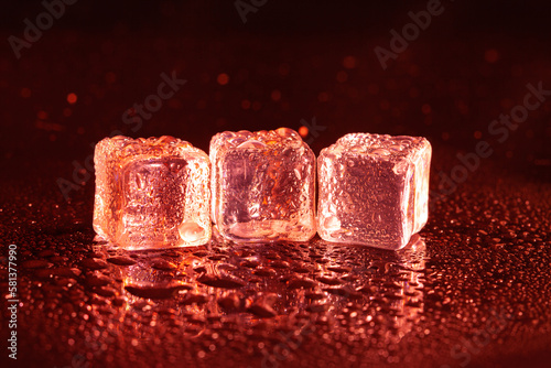 Red ice cubes on black background.