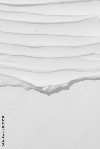 The texture of the white cream. Cosmetic background. Smears of body care cosmetics on a white background. Wellness and beauty concept. Top view.
