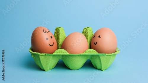 Cute easter eggs with funny faces in green box isolated on blue background. Happy easter concept. Stop motion easter animation