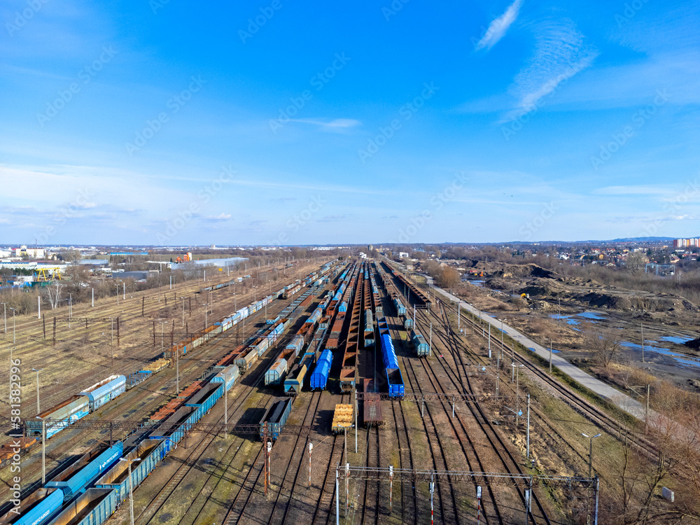 Aerial view landscape. View of railroad tracks and trains, cars, cargo. Blue sky.
