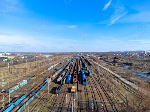 Obraz na płótnie Aerial view landscape. View of railroad tracks and trains, cars, cargo. Blue sky. w salonie