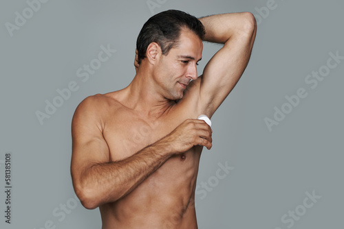 Fresh as a daisy. Cropped studio shot of a handsome mature man applying deodorant to his underarms.