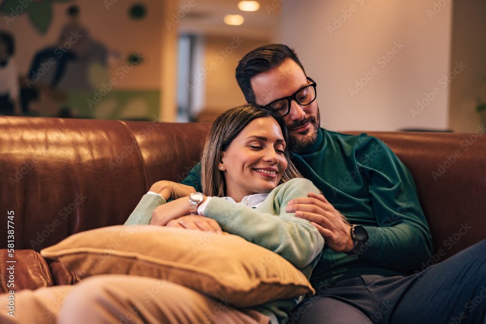 Obraz premium Two lovers taking a nap on the couch, looking happy.