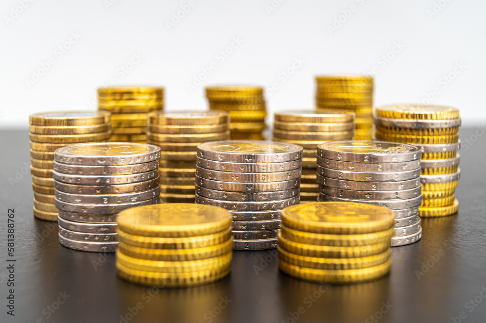 Stacks of coins next to each other, on black surface. Amount of money and wealth.
Stacks of coins next to each other, on black surface. Amount of money and wealth.