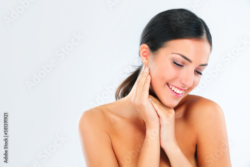 Shes perfectly pure. a beautiful young woman in studio feeling her soft skin.