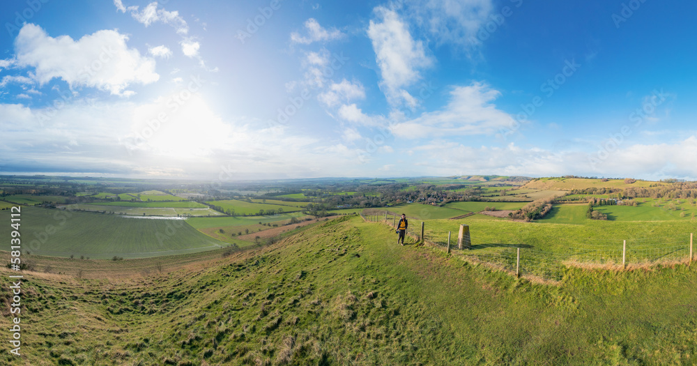 Obraz premium backpacker walking on footpath, beautiful hill and landscape near Pewsey, South of England, United Kingdom