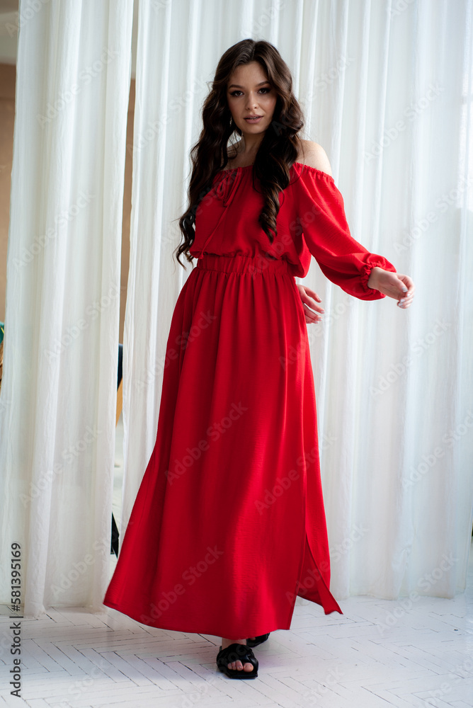 Beautiful smiling woman in long red dress sensual posing Beautiful smiling woman in long red dress sensual posing