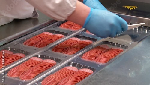 conveyor at the meat processing plant for the production and packaging of sausage cuts