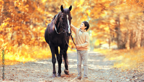 Happy teenager boy child and horse walking in forest © rohappy
