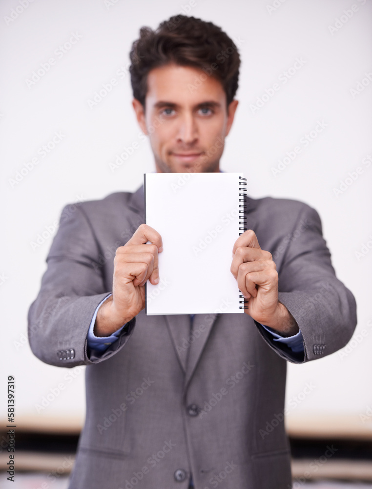 A message from the boss. A young businessman holding up a notepad. A message from the boss. A young businessman holding up a notepad.