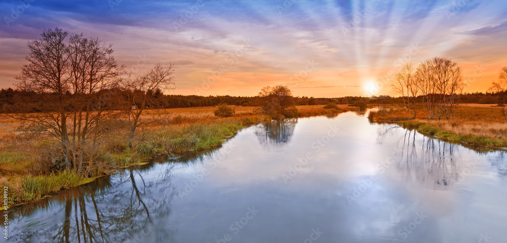 Sunset by a small river. Panoramic sunset shot by a small river.