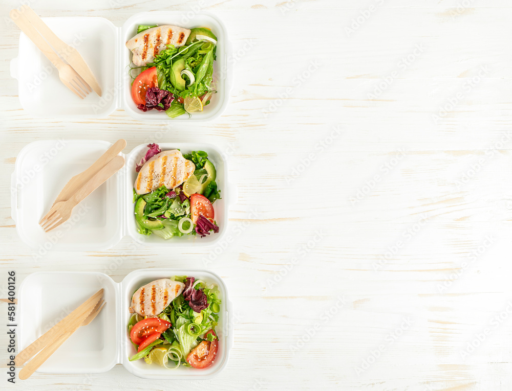 Food delivery of lunch boxes with salad on white wooden background. Copy space. Food delivery of lunch boxes with salad on white wooden background. Copy space.