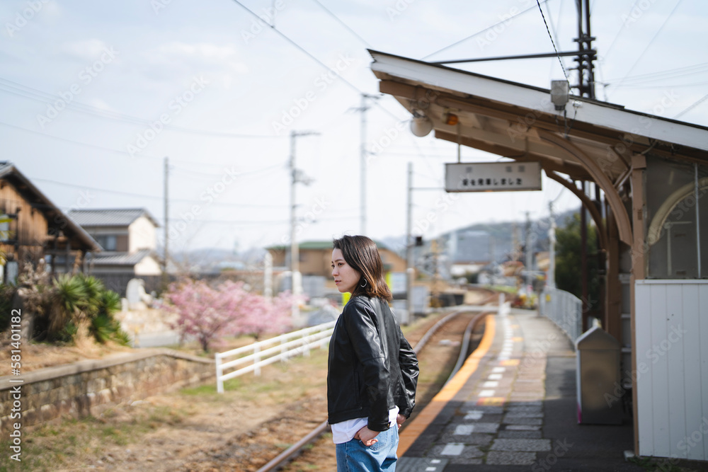 ローカル線の無人駅にいる女性